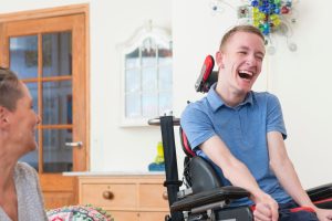Man in wheelchair laughing with a woman