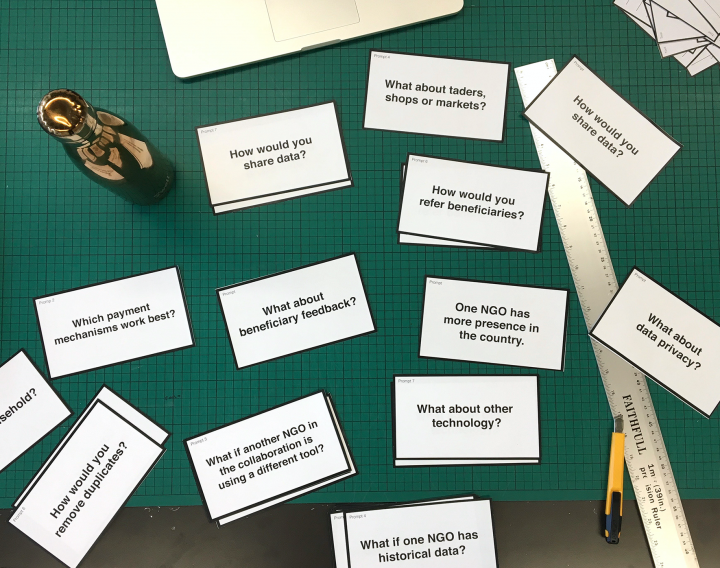 a photograph of a table top with lots of small white cards with What If statements on
