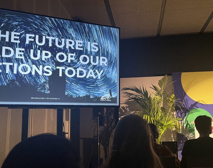 photo of Dr Leyla Acaroglu speaking at Design for Planet with a large screen showing the text 'The future is made up of our actions today'