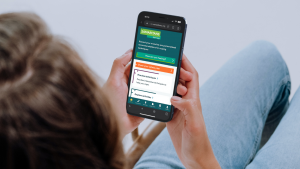 A user sitting on a couch on their mobile phone, browsing the Samaritans Self-Help app webpage - https://selfhelp.samaritans.org/